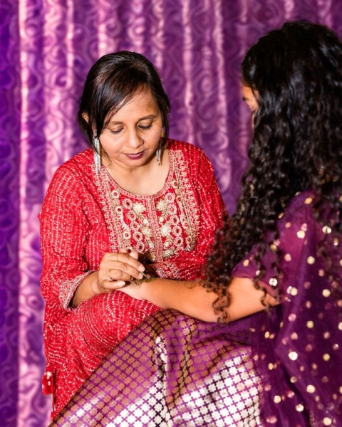 Nisha applying henna on a bride before wedding in Austin, Texas