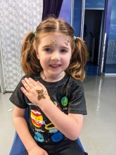Cute little girl getting henna on kids care center by Nisha