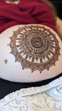 Beautiful motif by henna on pregnant belly - a gesture of welcoming the kid